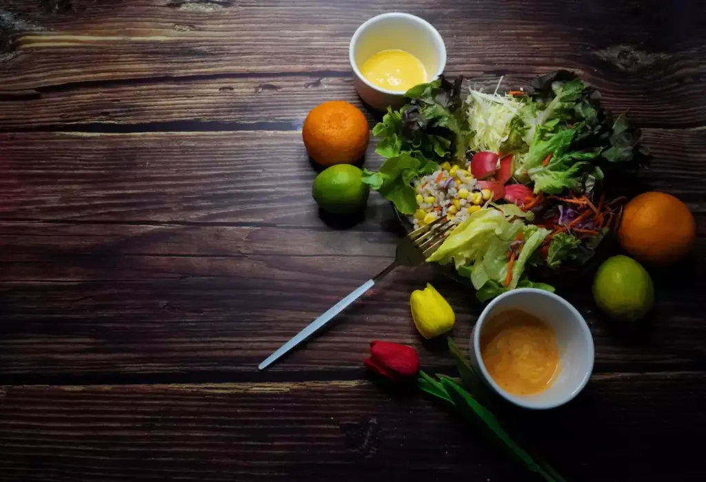 A stylized still life depicting an assortment of healthy foods and beverages on a wooden table, set against a soft, out-of-focus background. In the foreground, various prostate-friendly ingredients such as leafy greens, berries, nuts, and whole grains are arranged in an aesthetically pleasing manner. The lighting is warm and natural, creating a cozy and inviting atmosphere. The composition emphasizes the vibrant colors and textures of the fresh produce, conveying the idea of a nourishing, balanced diet suitable for post-prostatectomy recovery. The overall scene radiates a sense of wellness, health, and vitality.